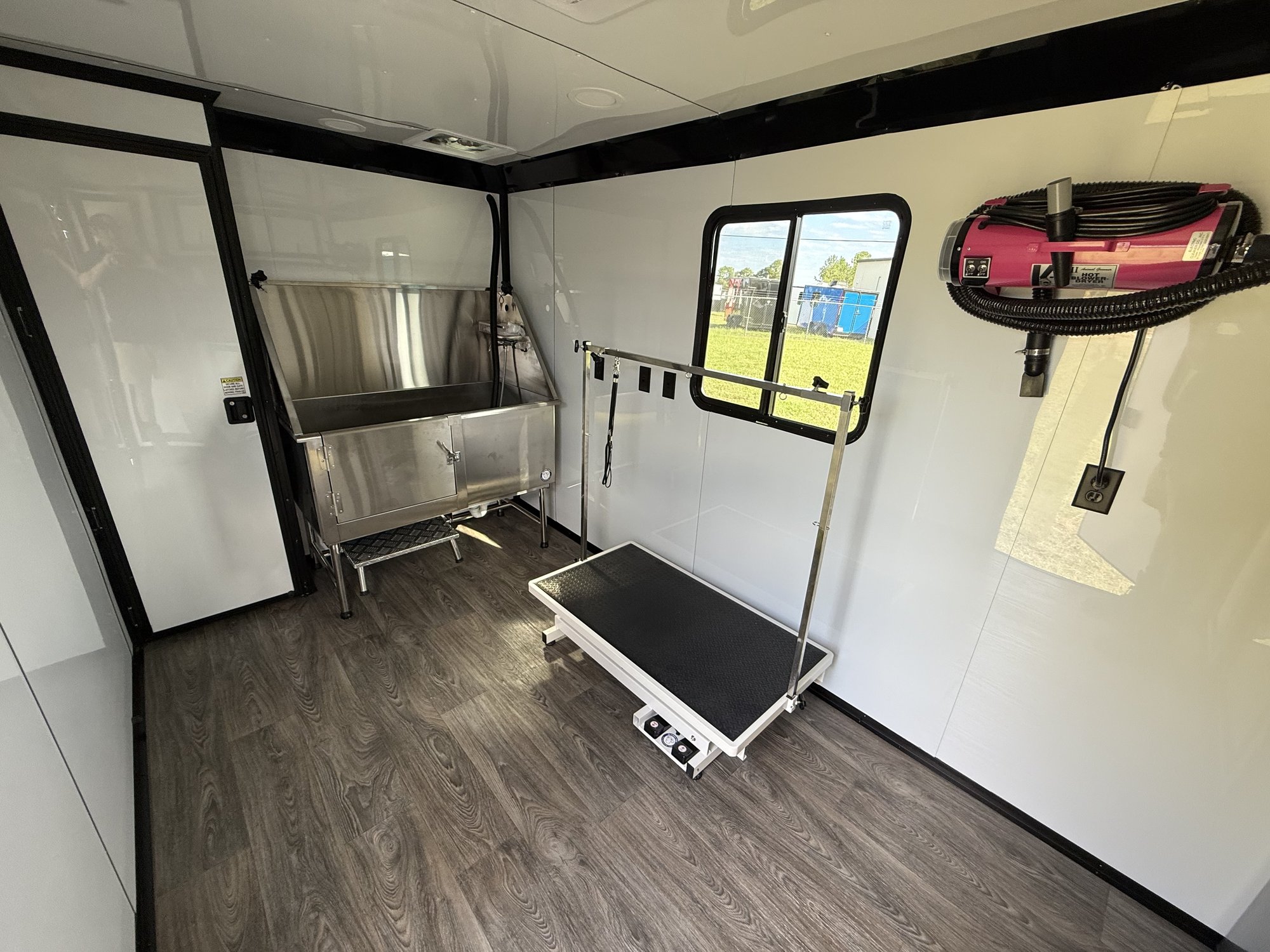 Inside the Pawsh Pup Parlor grooming trailer: bathing tub and grooming table.